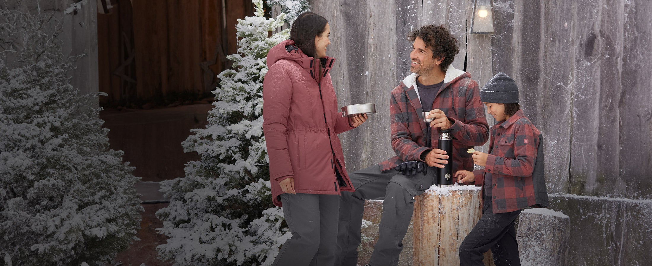 Vrouw, man en jongen dragen kleding uit de e.s.iconic-collectie in winterse omgeving